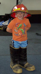 child wearing fire boots and fire helmet